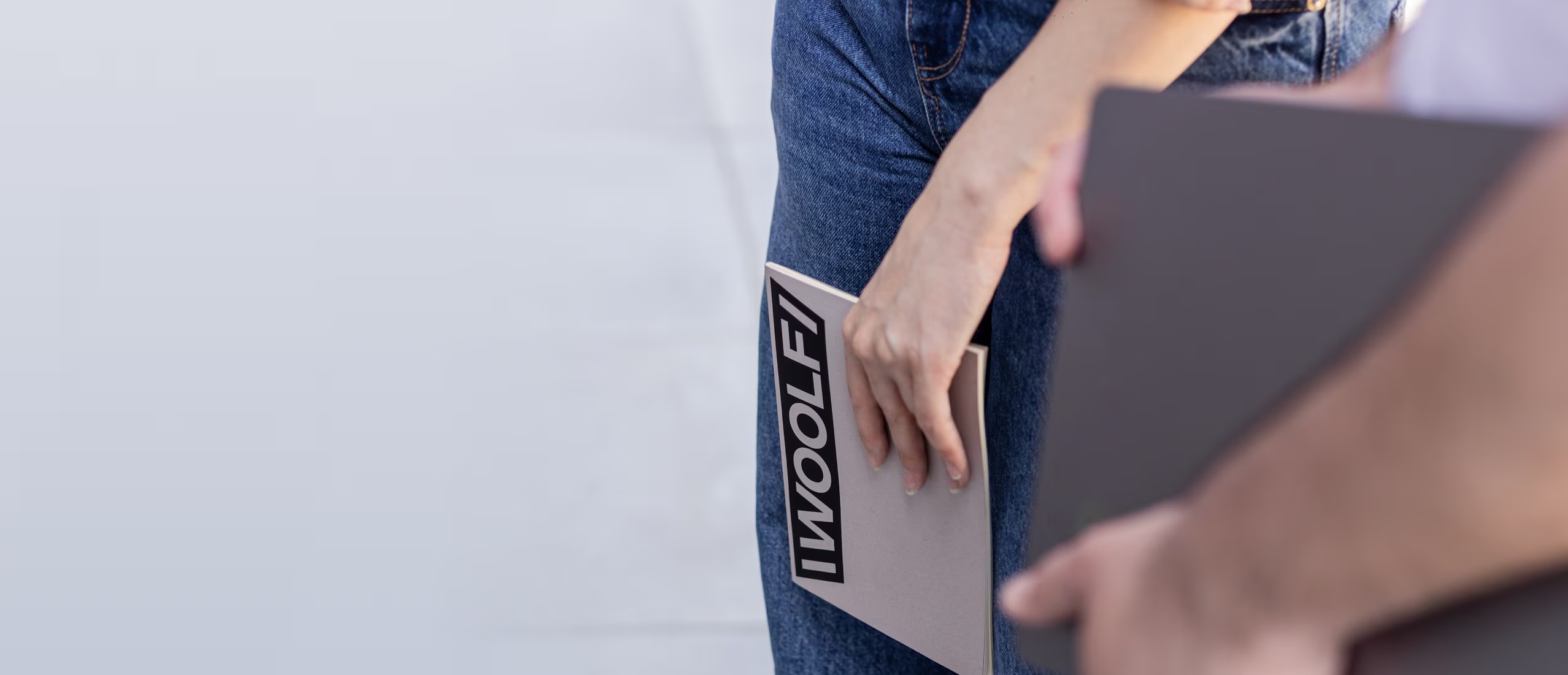Person holding a Woolf-branded folder.